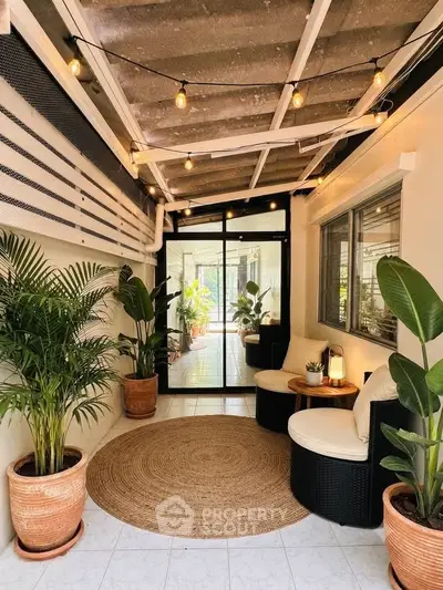 Charming covered patio with cozy seating and lush plants, perfect for relaxation and entertaining.