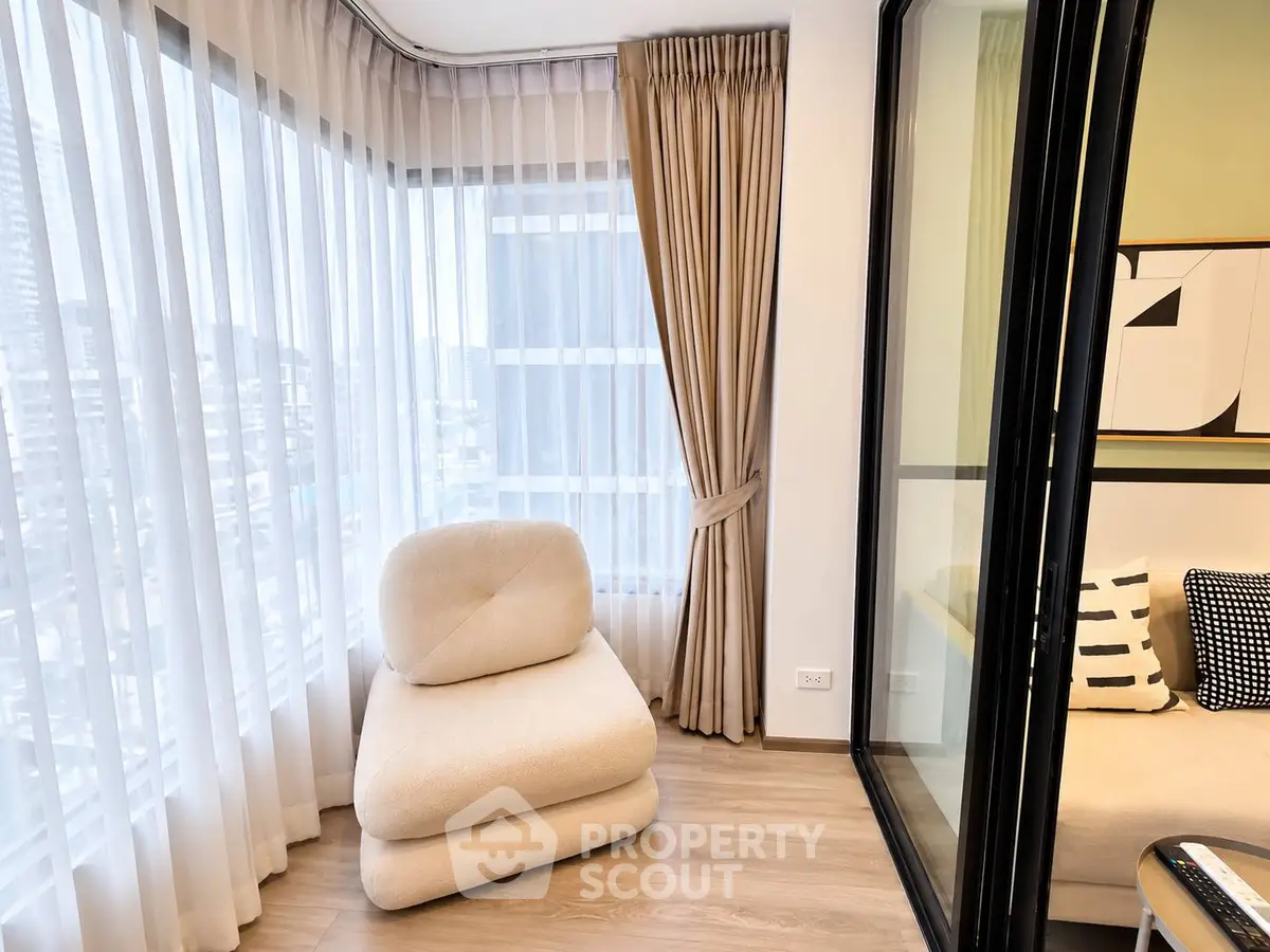 Modern corner unit with floor-to-ceiling windows and cozy seating area in a stylish apartment.
