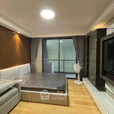 Modern bedroom with sleek design, large window, and stylish furniture in a contemporary apartment.