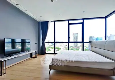 Spacious modern bedroom with floor-to-ceiling windows offering stunning city views.