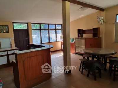 Spacious open-layout kitchen and dining area with natural light and wooden accents.