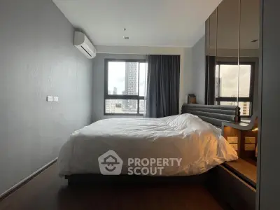 Modern bedroom with city view, featuring sleek design and ample natural light.