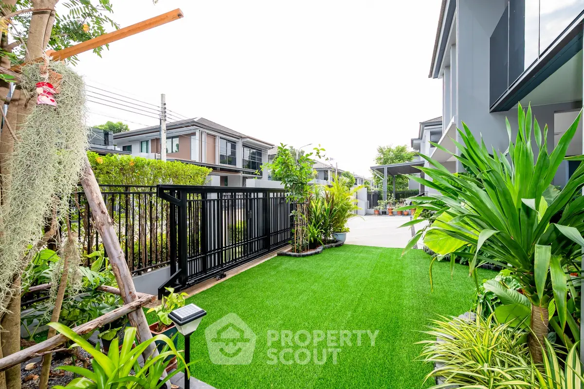 Beautiful modern garden with lush greenery and sleek fencing in a contemporary residential area.