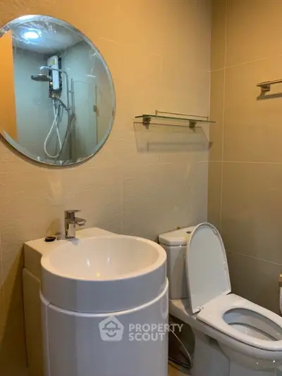 Modern bathroom with round mirror and glass shower enclosure