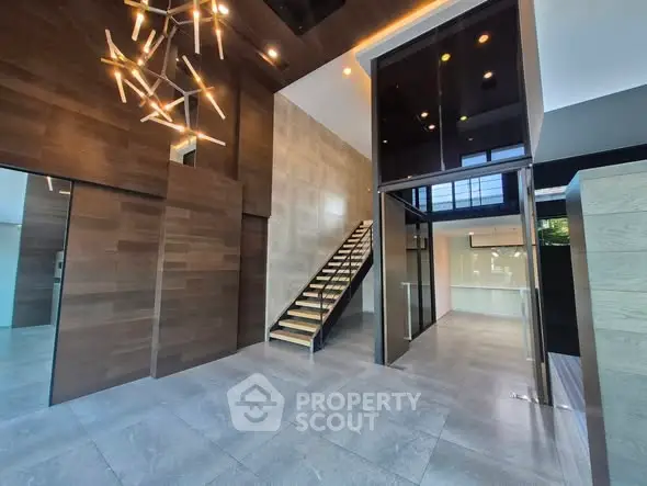 Modern entrance with sleek staircase and unique lighting in luxury property