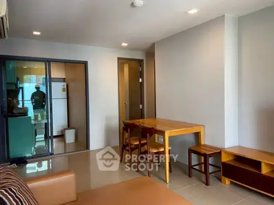 Modern living room with dining area and kitchen view in open layout apartment.