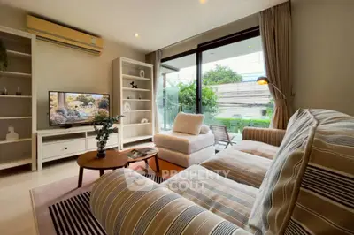Spacious living room with cozy seating and large window view