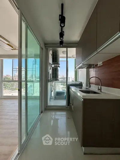 Modern kitchen with sleek cabinetry and large windows offering city views