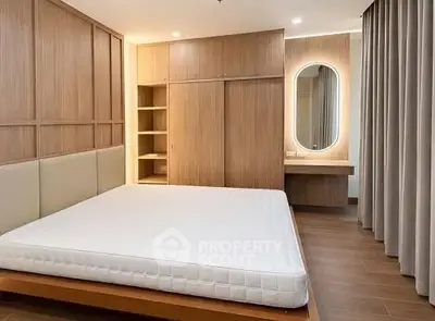Modern bedroom with wooden accents and built-in wardrobe, featuring a stylish vanity mirror.