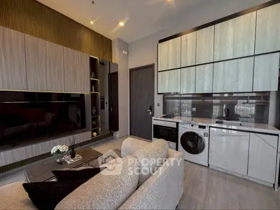 Modern living room with integrated kitchen, featuring sleek cabinetry and built-in appliances.
