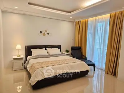 Spacious bedroom with elegant decor and large window for natural light.