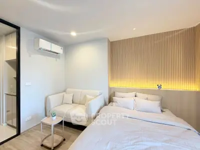 Modern bedroom with cozy sofa and stylish lighting, perfect for relaxation and comfort.