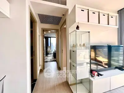 Modern apartment interior with hallway and living area, featuring sleek storage solutions and natural light.