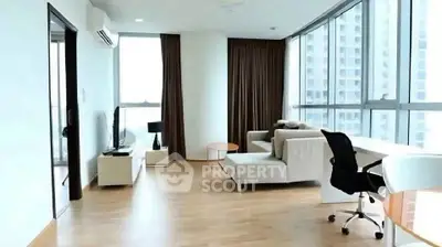 Spacious modern living room with large windows and stylish furniture in a high-rise apartment.