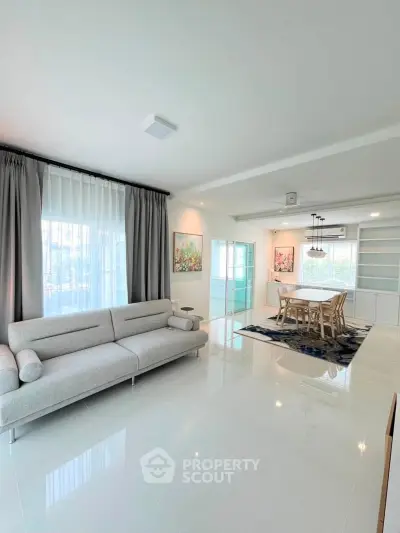 Spacious modern living room with elegant dining area and natural light
