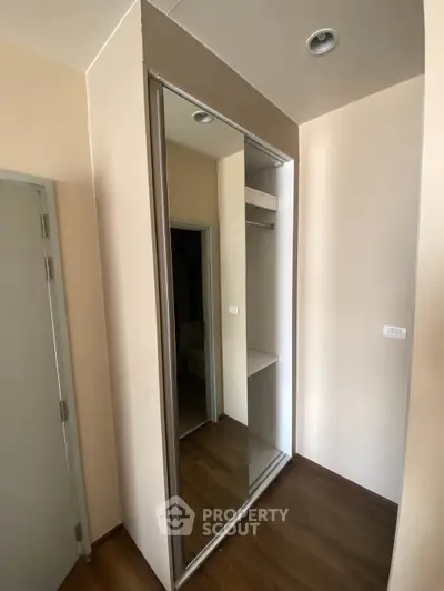 Modern apartment interior with sleek mirrored closet and wooden flooring