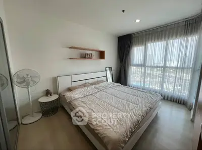 Modern bedroom with large window and stylish decor in a high-rise apartment.