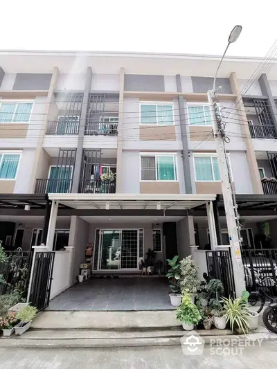 Modern townhouse exterior with balcony and driveway in urban setting