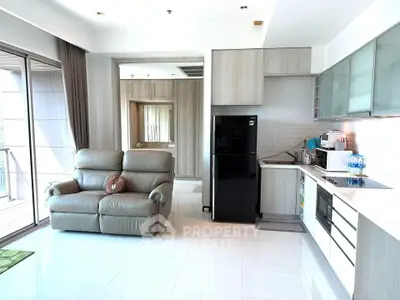 Modern open-layout living room with sleek kitchen and large windows in a stylish apartment.