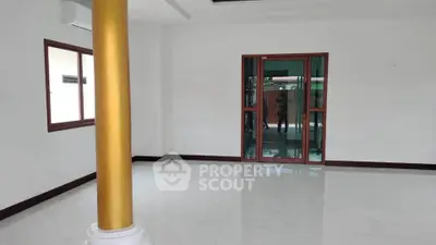 Spacious empty room with golden pillar and large windows, ideal for customization.