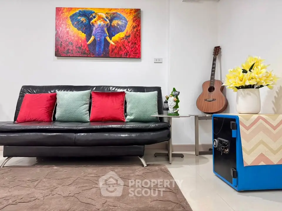 Stylish living room with modern decor, vibrant artwork, and cozy seating area.