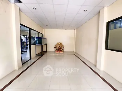 Spacious interior room with tiled flooring and glass partitions, ideal for office or retail space.