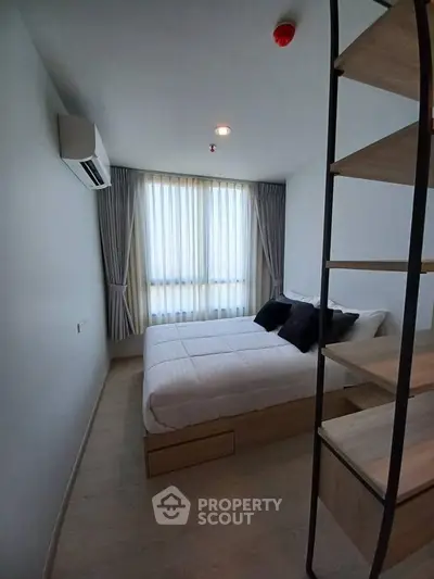 Modern bedroom with minimalist design and natural light, featuring a cozy bed and stylish shelving.