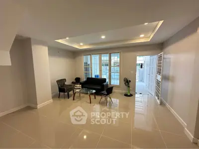 Spacious modern living room with sleek tile flooring and elegant recessed lighting.