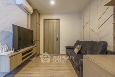 Modern living room with stylish decor, featuring a sleek TV setup and comfortable seating.