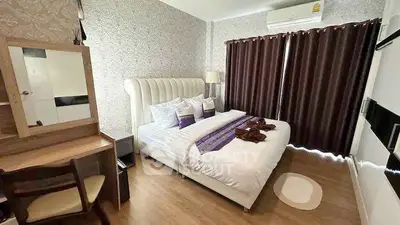 Elegant bedroom with stylish decor and natural light, featuring a plush bed and modern furnishings.