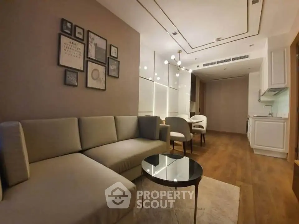 Modern living room with elegant decor and open kitchen layout, featuring cozy seating and stylish lighting.