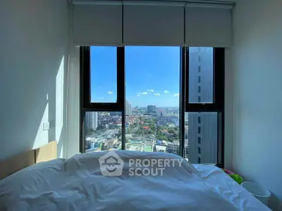 Stunning bedroom view with floor-to-ceiling windows overlooking city skyline, perfect for urban living.