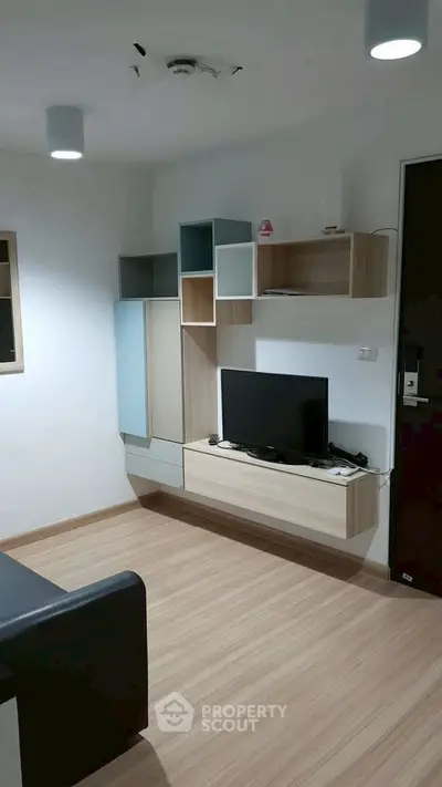 Modern living room with sleek wall-mounted TV unit and stylish storage shelves.