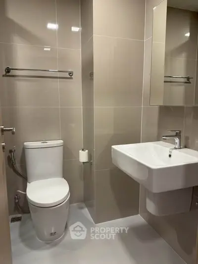 Modern bathroom with sleek fixtures and neutral tiles, perfect for a contemporary home.