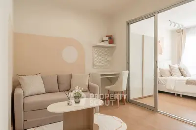 Modern living room with cozy sofa and sliding door to bedroom, perfect for urban living.