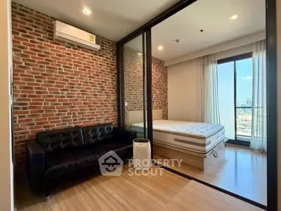 Modern apartment with brick accent wall, cozy living area, and spacious bedroom with large windows.
