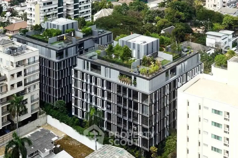 Modern urban apartment complex with rooftop gardens and sleek architecture.