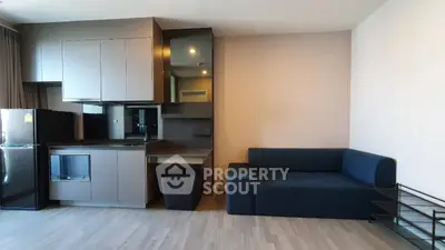 Modern apartment interior with sleek kitchen and cozy living area, featuring contemporary design and efficient use of space.