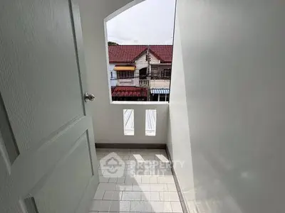 Charming balcony with tiled floor and neighborhood view, perfect for relaxation.