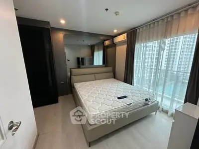 Modern bedroom with large window and city view, featuring a comfortable bed and sleek design.