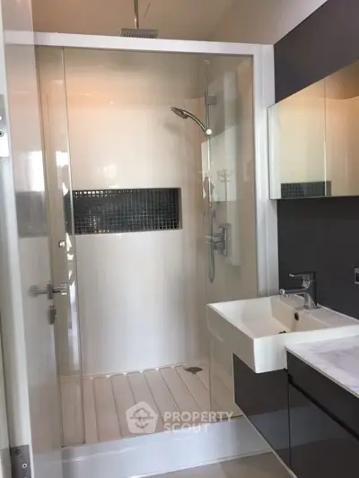 Modern bathroom with sleek shower and stylish vanity in contemporary home.