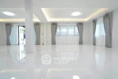 Spacious modern living room with large windows and elegant curtains