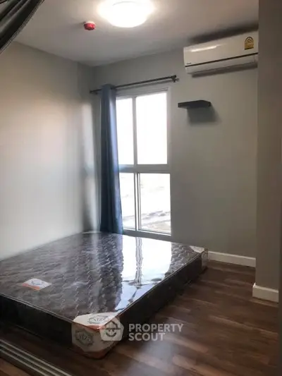 Modern bedroom with large window and air conditioning in stylish apartment.