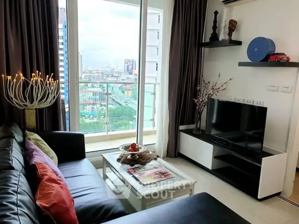 Modern living room with city view, stylish decor, and balcony access in a high-rise apartment.