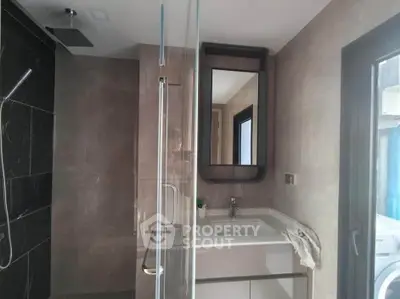 Modern bathroom with sleek design, featuring a glass shower and stylish vanity.