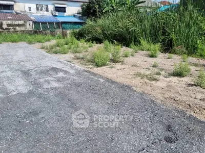Vacant land plot with gravel path and lush greenery, ideal for development opportunities.
