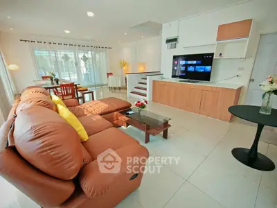 Spacious modern living room with leather sofa and entertainment center