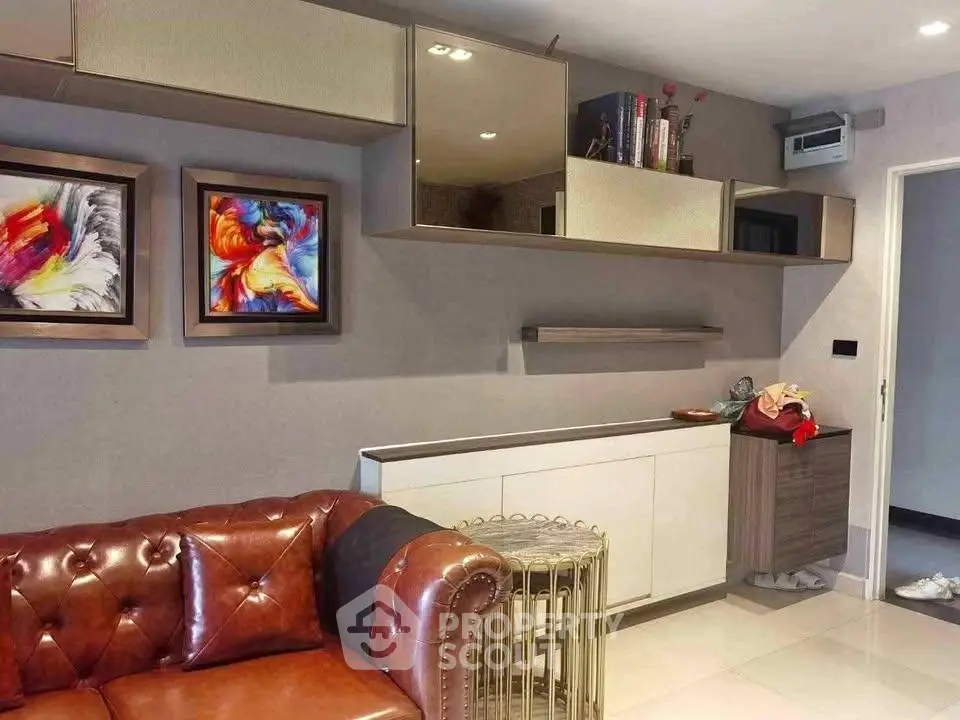 Stylish living room with modern art and leather sofa in contemporary apartment.