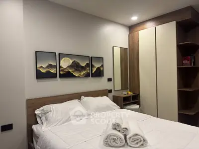 Modern bedroom with stylish decor and cozy ambiance, featuring a comfortable bed and elegant wall art.
