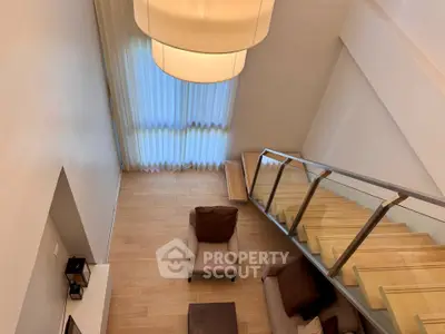 Modern duplex living room with stylish staircase and cozy seating area